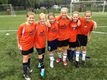 Youth soccer team posing on field